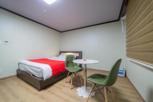 1 dormitorio con 1 cama, mesa y sillas en Hotel Castle en Suncheon