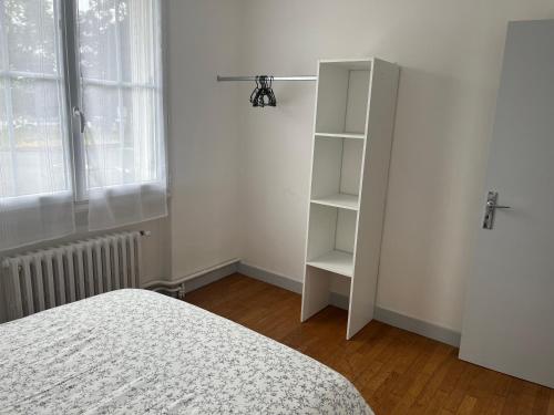a bedroom with a white book shelf next to a bed at Maison de ville in Valençay
