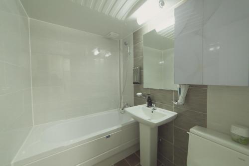 La salle de bains blanche est pourvue d'un lavabo et d'une baignoire. dans l'établissement Hotel Castle, à Suncheon