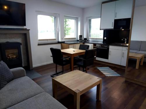 a living room with a couch and a table and a kitchen at Hotel Seeschlösschen in Groß Köris