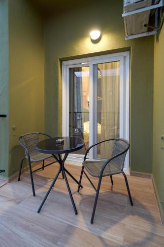 a table and two chairs in a room with a window at XANTHI POLIS CITY CENTER with private parking in Xanthi
