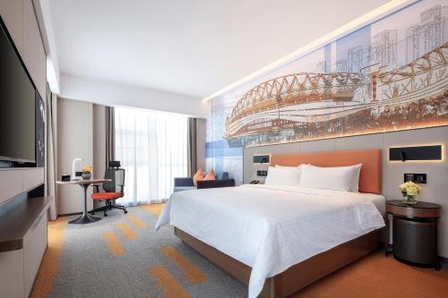 a hotel room with a bed and a tv at Hampton by Hilton Wuhan High-Speed Railway Station in Qingshan