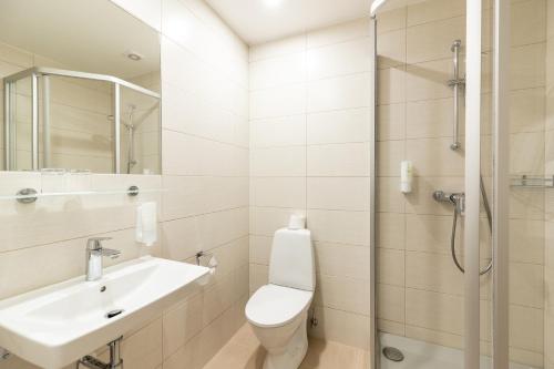 a bathroom with a toilet and a sink and a shower at Hotel Sigulda in Sigulda