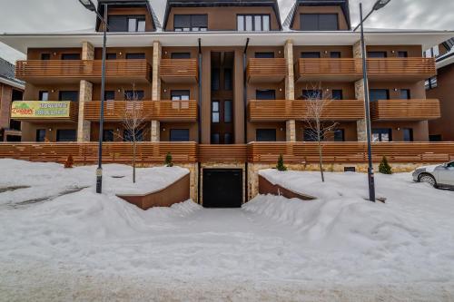 un edificio con una puerta en la nieve en Apartman Gondola SPA II en Zlatibor
