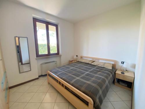 1 dormitorio con cama, escritorio y ventana en Green Residence - Apartment with Private Garden en Desenzano del Garda