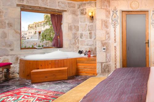 een badkamer met een bad en een raam bij Cappadocia Pema Cave Hotel in Ortahisar