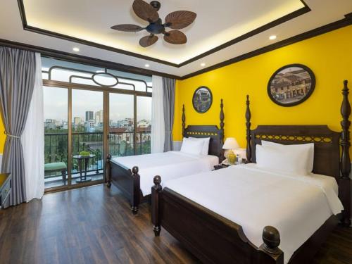 a bedroom with two beds and a large window at Charming beauty hotel in Da Nang