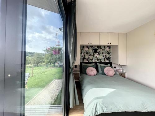 ein Schlafzimmer mit einem Bett und einem großen Fenster in der Unterkunft La Bricole in Dinant
