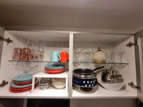 a cabinet filled with plates and bowls and dishes at Fewo - Charmante 2 Zimmer Wohnung mitten in Markdorf in Markdorf