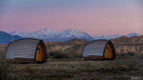 two domes in a field with mountains in the background at Remote. Forgotten Rivers in Ak-Say