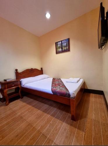 1 dormitorio con 1 cama y TV en la pared en Mojica Residencia, en Vigan