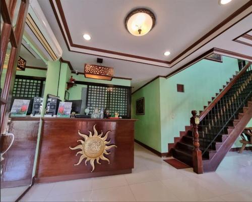 a lobby with a staircase and a store with a sun on the wall at Mojica Residencia in Vigan