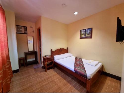 a small bedroom with a bed and a window at Mojica Residencia in Vigan