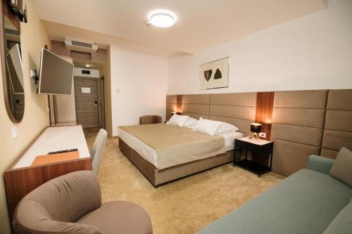 Hotel Slavija Lux في بلغراد: غرفه فندقيه بسرير وكرسي