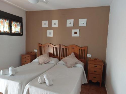 2 camas en un dormitorio con fotos en la pared en La Atalaya de Villalba, en Cuenca