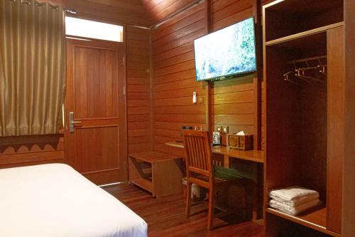 een slaapkamer met een bed, een bureau en een televisie bij Point of View Hotel & Resort Majalengka in Majalengka
