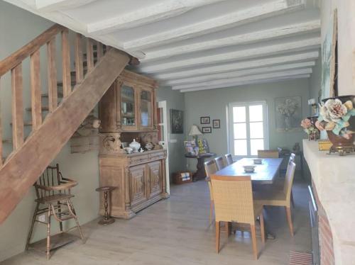 une salle à manger avec une table et un escalier dans l'établissement Le gîte de Sissi, à Lavardin