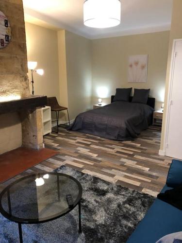 une chambre avec un lit et une table en verre dans l'établissement Escapade cosy au coeur de la cité médiévale, à Sarlat-la-Canéda