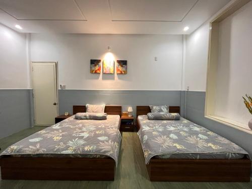 um quarto com duas camas e uma luz na parede em An Chi Homestay em Hue