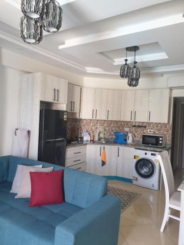 Sharm Hills في شرم الشيخ: غرفة معيشة مع أريكة زرقاء ومطبخ