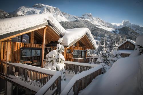 a snow covered log cabin with a snow covered mountain at Luxuslodge - Zeit zum Leben in Annaberg im Lammertal