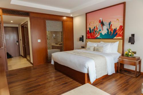 a bedroom with a large bed with a painting on the wall at Bang Onsen Spa & Resort in Bang
