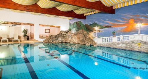 a large swimming pool with a mural on the wall at Best Western Victor's Residenz-Hotel Rodenhof in Saarbrücken