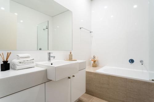La salle de bains blanche est pourvue d'un lavabo et d'une baignoire. dans l'établissement Dunn Bay Apartment 6, à Dunsborough