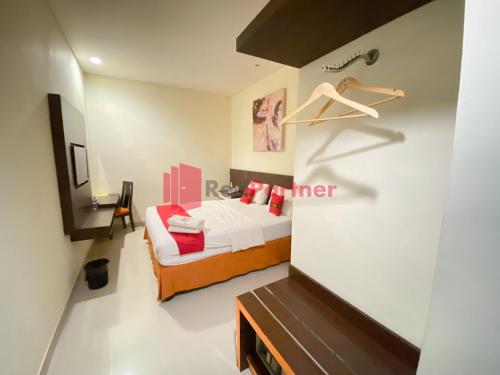 a small bedroom with a bed and a closet at Hotel Alpha Makassar RedPartner in Makassar