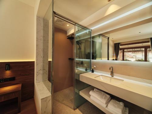 uma casa de banho com um lavatório e um chuveiro em Saturday Inn em Lijiang