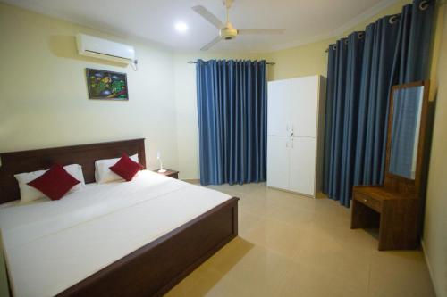 um quarto com uma cama grande e cortinas azuis em Serene Haven in Colombo 8 em Colombo