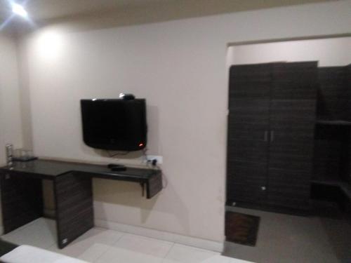 a room with a tv and a desk with a monitor at iROOMZ Hoysala Residency in Bellary