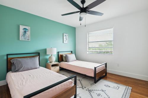 a bedroom with two beds and a ceiling fan at Amazing 2 Bedroom Townhouse near beach in Indialantic