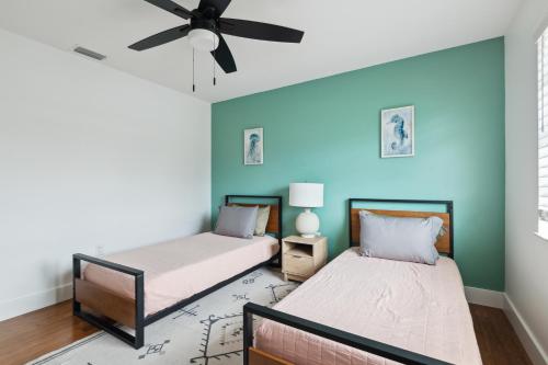 two beds in a room with a ceiling fan at Amazing 2 Bedroom Townhouse near beach in Indialantic