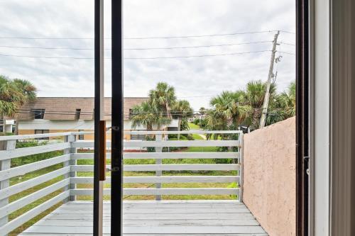 a window view of a fence and palm trees at Amazing 2 Bedroom Townhouse near beach in Indialantic