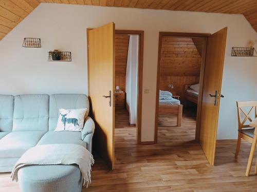 a living room with a couch and a bedroom at Ferienwohnung Brentenholz in Sankt Georgen im Schwarzwald