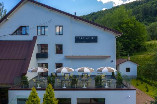 a large white building with tables and chairs at Yaremche Club Hotel in Yaremche