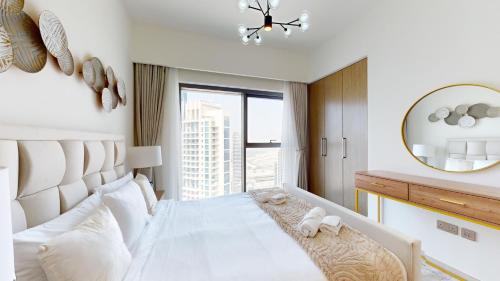 杜拜的住宿－Primestay - Burj Royale 3BR plus Maids，卧室配有一张带镜子的白色大床