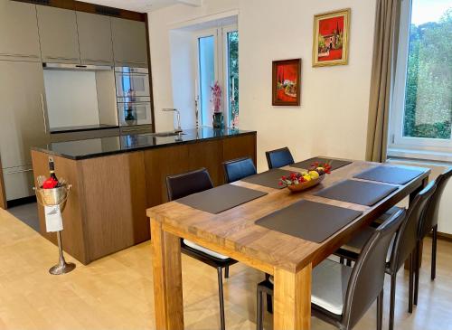 eine Küche und ein Esszimmer mit einem Holztisch und Stühlen in der Unterkunft Gästehaus Casa Cecilia in Wetzikon