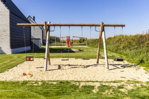 a swing set in a park with a playground at Haus Berg-Ahorn in Büsum