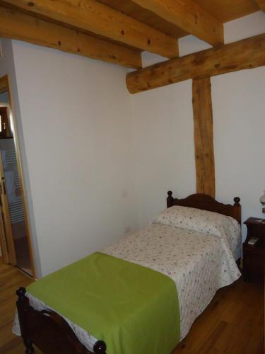 a bedroom with a bed in a room with wooden beams at Agriturismo Al Gelso in Risano