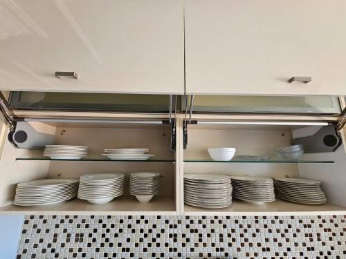 a cabinet filled with white plates and bowls at The Most Luxurious Apartment-The Flat New York in Ankara