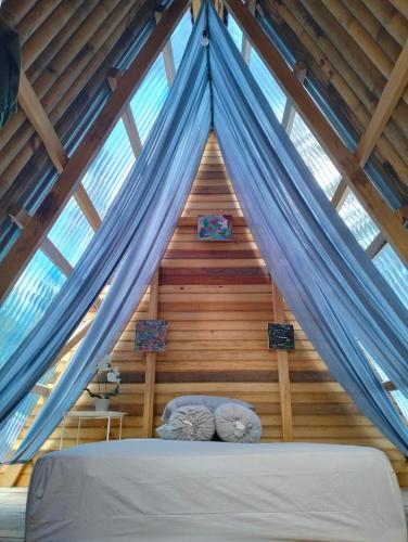 a bedroom in a wooden cabin with a bed at Sirus Base Camp Tagulandang in Kisihang