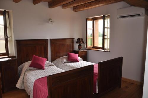 a bedroom with two beds with pink pillows at Agriturismo Al Gelso in Risano