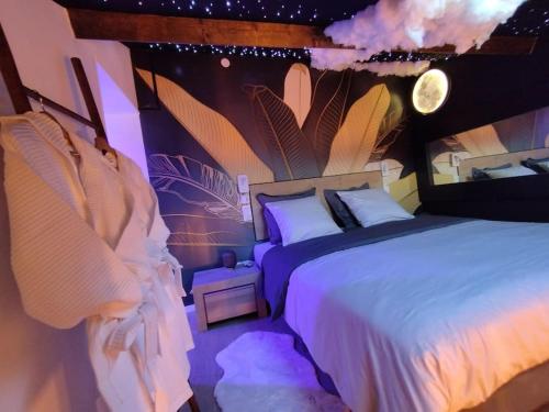 sypialnia z dużym łóżkiem z fioletowym oświetleniem w obiekcie Bulles et belle étoile SPA proche de Caen w mieście Sainte-Croix-Grand-Tonne