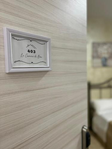 a sign on a wall in a bedroom at Le Camere di Bea in Tivoli Terme