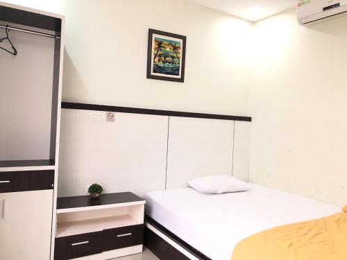 a small bedroom with a bed and a mirror at RedDooz Plus At Ininnawa Homestay Syariah Palu in Palu