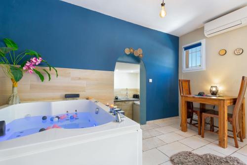 a blue bathroom with a tub and a table at Appartement jacuzzi 4 étoiles - Love Room Beauté in Puget-sur Argens