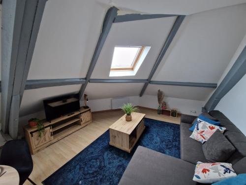T2 tout confort, idéal séjour pro : غرفة معيشة في العلية مع أريكة وتلفزيون