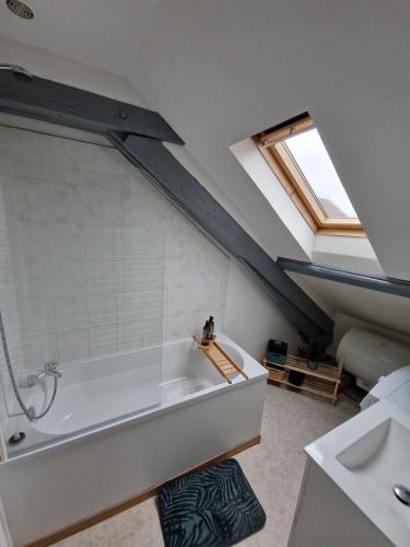 La salle de bains est pourvue d'une grande baignoire et d'une lucarne. dans l'établissement T2 tout confort, idéal séjour pro, à Marpent